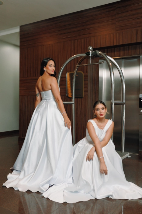 Noivas com vestidos acetinados posando no hall antes da cerimônia